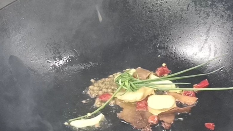 红焖牛肉煲,起锅烧油,放入卤料炒香,加入花椒粒和葱姜蒜炒香
