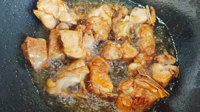板栗排骨煲,下排骨迅速翻炒,尽量让每块排骨都裹上糖色