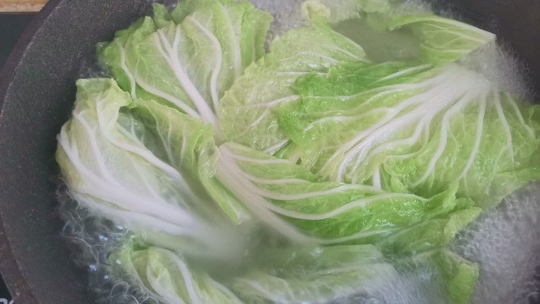 白菜卷肉,锅里烧水,加入适量的盐和油,水开下入白菜焯水半分钟捞出控干水分
