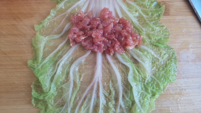 白菜卷肉,取一张白菜叶子,夹入适量的肉馅,从上往下卷起来,