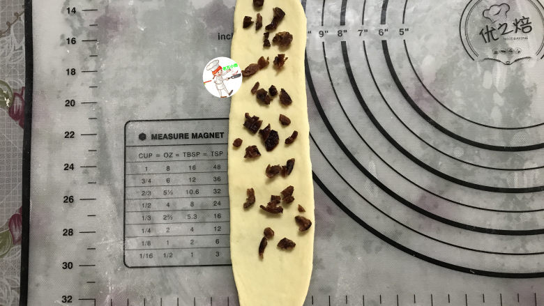 淡奶油小餐包,取一个小面团,用擀面杖轻轻推开、擀长,放上少许的蔓越莓粒