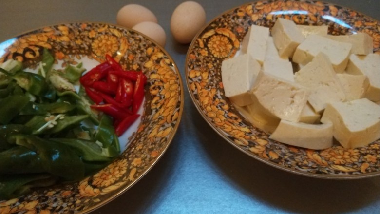 鸡蛋炖豆腐,青辣椒洗干净,切成块儿。小米辣洗干净,切成小段儿。豆腐切成厚一点儿的片儿,准备三