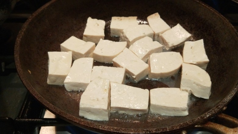 鸡蛋炖豆腐,平底锅放入适量的油,放入豆腐,兼职两面金黄即可。