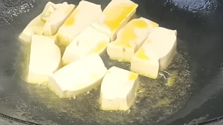 鸡蛋炖豆腐,起锅烧油,放盐,再放入豆腐,煎至两面金黄
