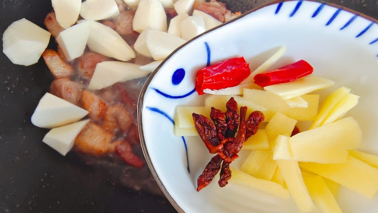 茭白茄子焖肉,加入茭白,加入生姜八角干红辣椒,翻炒均匀