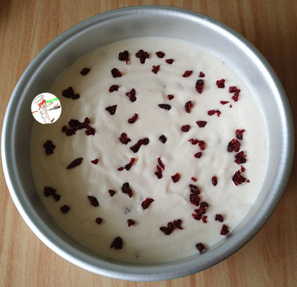 果子蛋糕,取一个8寸活底模具,把做好的蛋糕糊从高处倒入模具里,轻震几下震出大气泡,再将余下的蔓越莓粒撒在表面