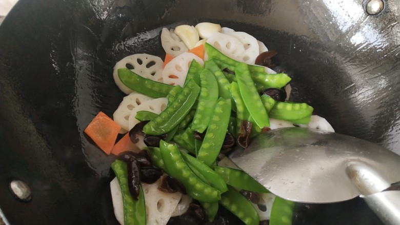荷兰豆藕片,加入荷兰豆和黑木耳略炒一下,加入适量开水烧一分钟左右