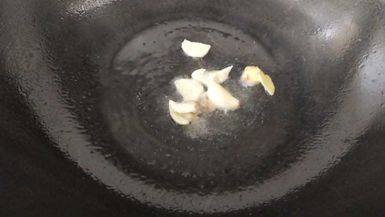 杏鲍菇炒虾仁,锅里放油烧热,把蒜瓣和姜片炒香