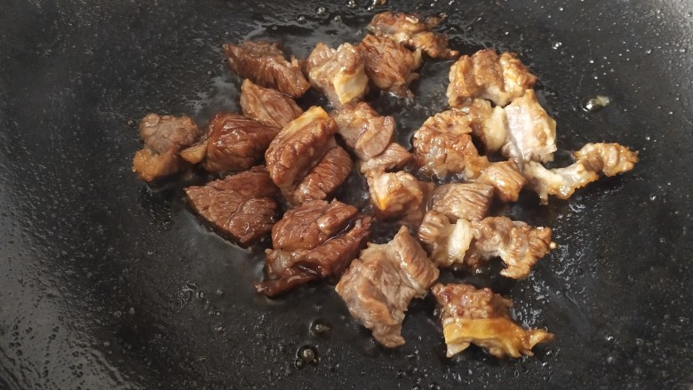 牛肉炖芋头,倒入牛肉翻炒,让每一块牛肉都能裹上冰糖