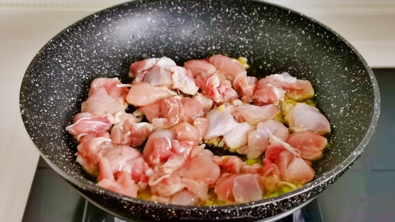 香菇板栗焖饭,起油锅,加入葱花蒜末炒比出香味,加入鸡块翻炒变色。