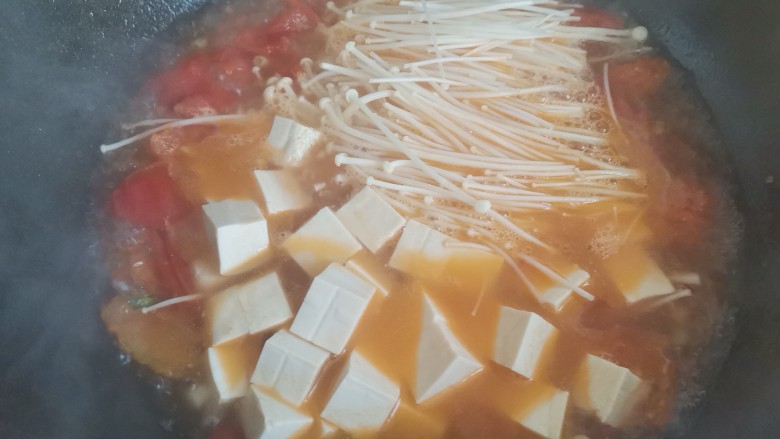 金针菇番茄汤,水开下入金针菇,豆腐,继续煮