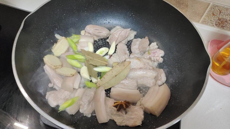 五花肉焖莲藕,等五花肉变色后,加入葱姜蒜香叶八角炒出香气