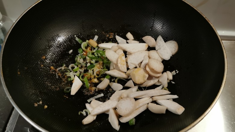 虾仁豆腐煲,锅中留下底油继续加热,放入葱片炒香,放入杏鲍菇片翻炒。