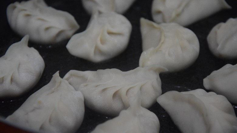 白菜猪肉煎饺,起锅热油,放入饺子煎至底部焦黄