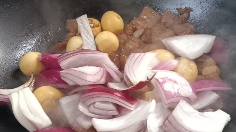 鹌鹑蛋红烧肉,约10分钟后,放入洋葱,翻炒均匀