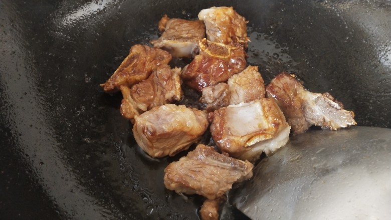 香菇板栗焖饭,倒入排骨,翻炒均匀,让每块排骨都能裹上冰糖