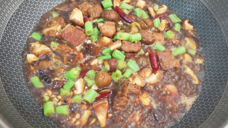 香菇板栗焖饭,排骨煮半个小时以后基本上已经入味了,下入豆角、香菇和板栗翻炒均匀,煮3分钟关火。