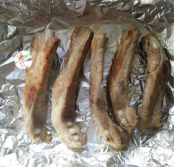 奥尔良烤排骨,20分钟后取出排骨,打开锡纸,表面刷蜂蜜水,翻面,再刷蜂蜜水