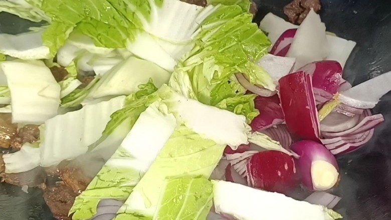 洋葱菜梗炒腊肠,放入洋葱和菜梗,翻炒均匀至断生