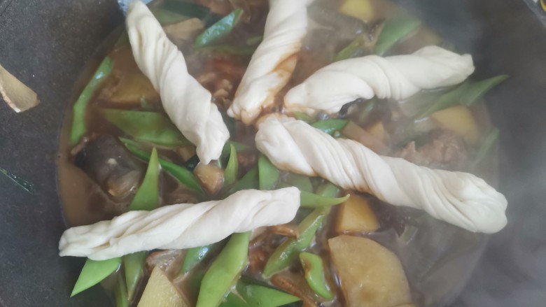 豆角焖卷子,炖至汤汁变少,把花卷放进去,小火闷十分钟