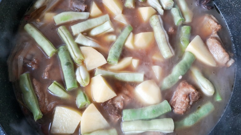 豆角焖卷子,再加入豆角,土豆翻炒至豆角变色。