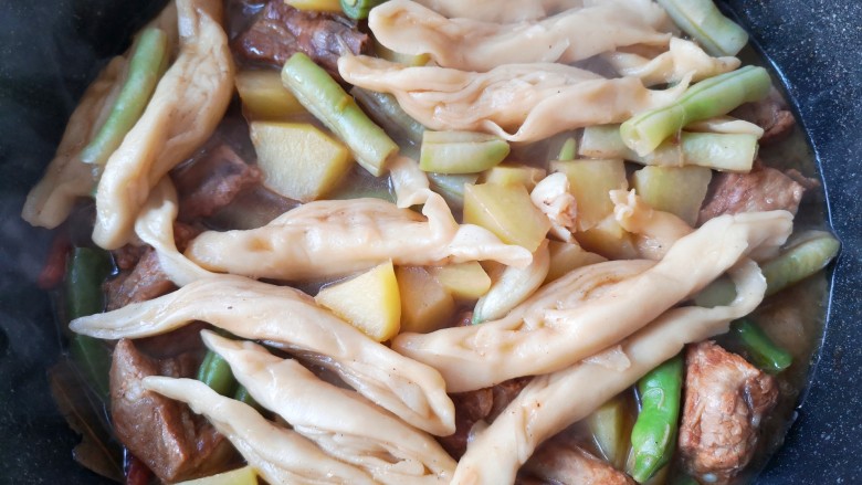 豆角焖卷子,待汤差不多干了加入拍散的大蒜和少量的冰糖。菜熟、卷子香,一锅出!