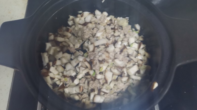 虾米粉丝煲,加入肉末翻炒至变色,加入香菇丁翻炒均匀