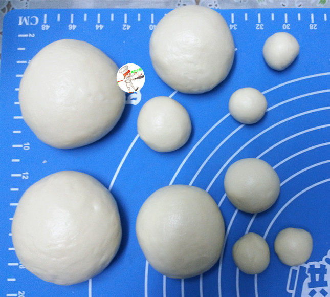 圣诞老人面包,取出面团排气,按比例分成小面团,搓圆,盖膜松弛20分钟,比例为:
A、先将面团按总重量分成:分成2份(做圣诞老人)
B、再将大面团,拆分成3份,比例是50%(身体),30%(胡须),20%(鼻子、帽沿和帽子上面的绒球)
C、接着将20%的小面团:再拆分成3份,比例为6(帽沿):2(鼻子):2(帽子上面的绒球)