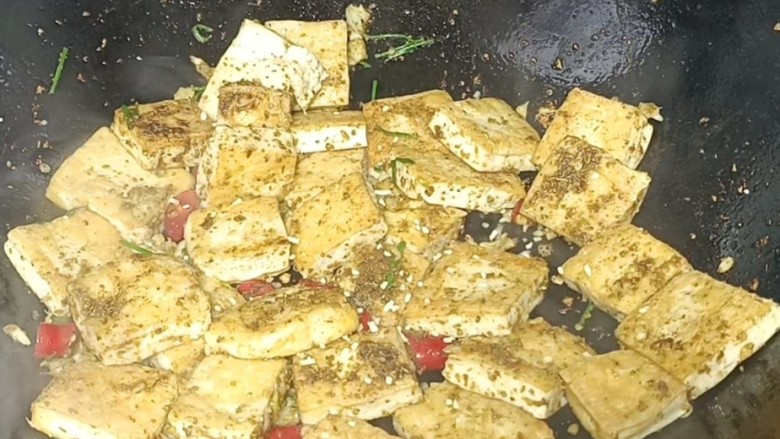 孜然煎豆干,翻炒均匀后,撒人鸡精粉,翻炒均匀