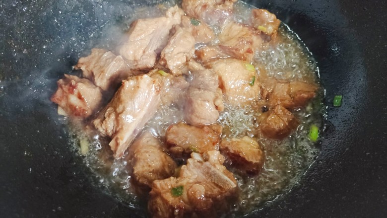 番茄烧排骨,起油锅,油热后下排骨,翻炒至变色