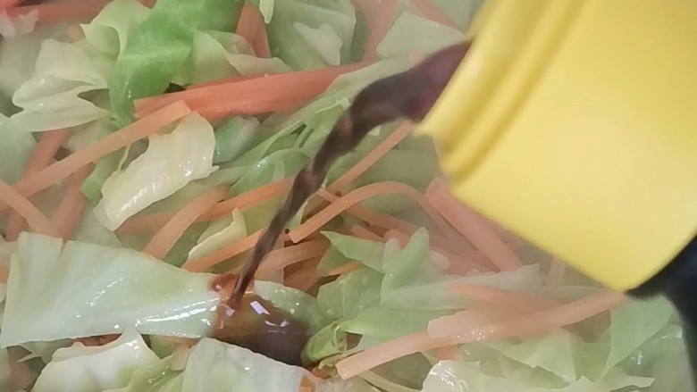 包菜胡萝卜炒鸡蛋,倒入包菜胡萝卜翻炒均匀,加入一勺<a style='color:red;display:inline-block;' href='/shicai/ 788'>生抽</a>