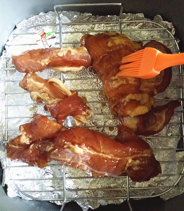 香酥五花肉,摆入空气炸锅的烤架上,并且在肉的两面刷上腌肉汁,200度烤20~25分钟左右