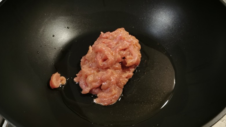 京葱炒肉丝,起油锅放入食用油，油热后放入瘦肉丝翻炒。