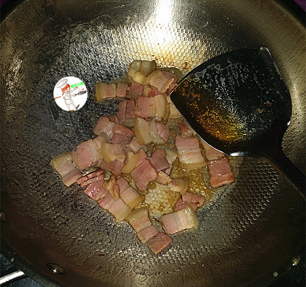 咸肉炒大蒜,炒至咸肉变色,出油,烹入1勺料酒和少许温水,煮至2~3分钟,将咸肉煮熟