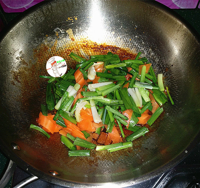 咸肉炒大蒜,接着把胡萝卜、蒜叶及煸炒过蒜白一起放入锅中,大火翻炒
