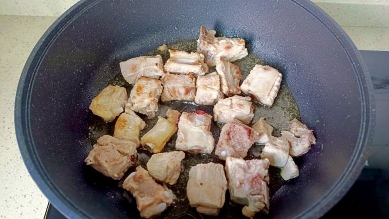 番茄烧排骨,锅里放油,下排骨煎两面金黄。