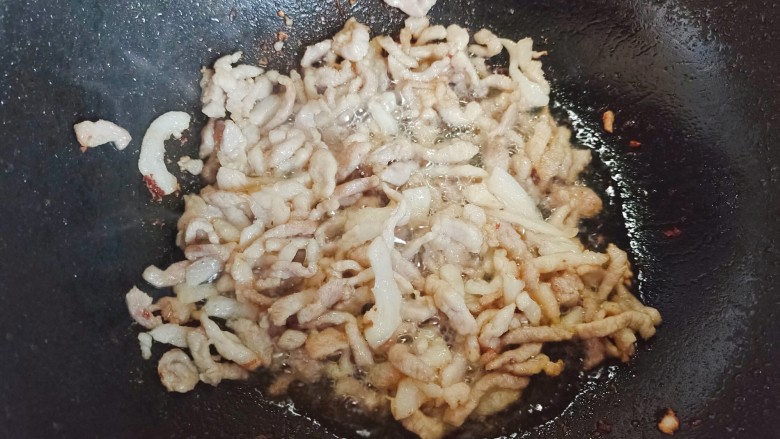 京葱炒肉丝,起油锅,油热后下肉丝,煸炒至肉丝稍稍呈金黄色,并有油脂逼出来
