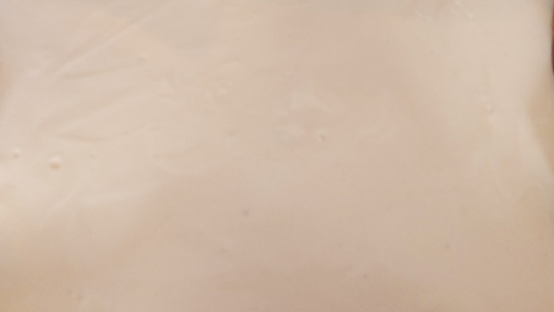 草莓抱抱卷,倒入预先铺好油布的烤盘中,震去气泡,,用刮刀刮平