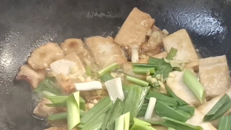 口蘑腊味豆腐,加入盐,姜末和青蒜炒香