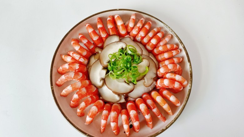 家常虾仁拼盘,对虾剪去虾头虾尾,再剥壳依次摆盘码好,中间放上香菇片,葱丝。