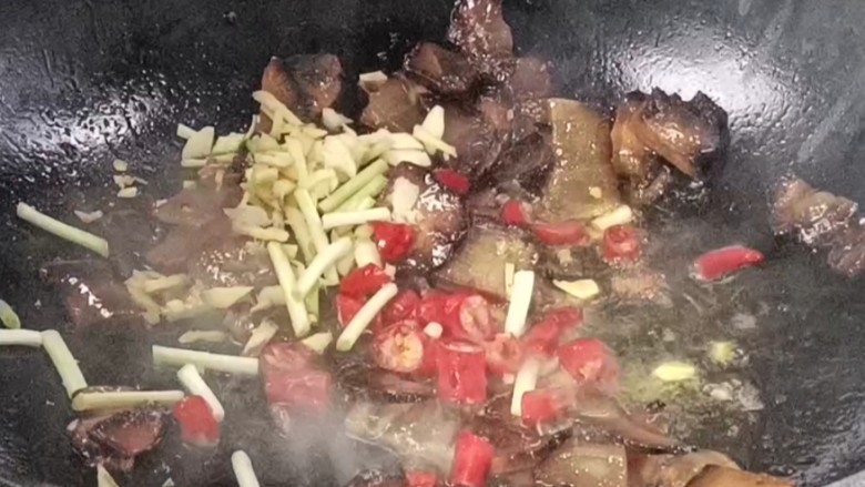 酱油肉炒萝卜,倒入葱姜蒜,红尖椒,炒出香味,