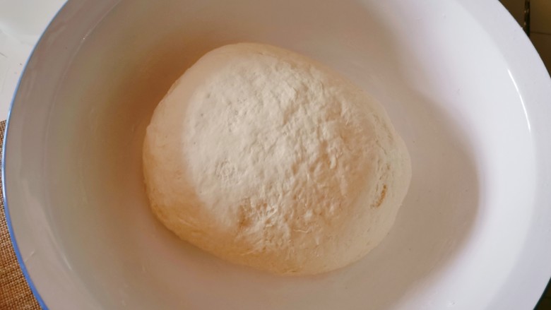 豆腐包子,面粉和酵母粉一起放入面盆中,加入适量温水和面,软硬适中即可,静置发酵。