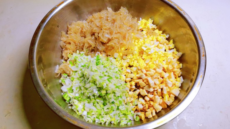 豆腐包子,盛出放入馅料盆里,大<a style='color:red;display:inline-block;' href='/shicai/ 3250'>葱</a>切碎,鸡蛋碎,豆腐丁,粉条一同放入盆中。