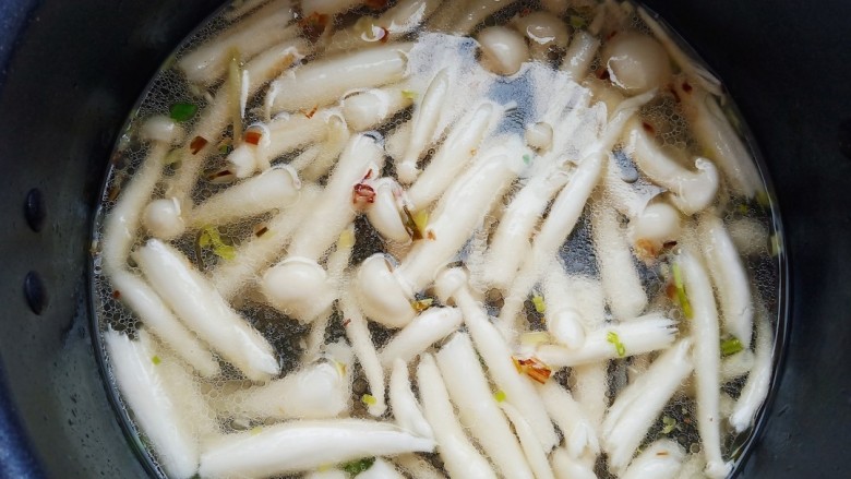 鲫鱼豆腐菇菌汤,锅中烧油,加入葱姜蒜爆香,加入适量清水和菌菇炖煮。