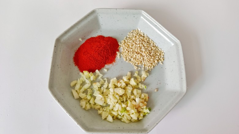 凉拌菠菜,碗里放蒜蓉,芝麻,辣椒粉。