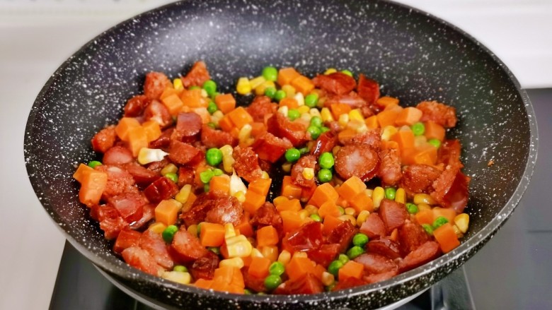 腊味糯米饭,加入时蔬翻炒。(玉米粒,豌豆,胡萝卜丁)