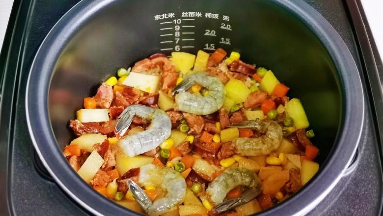 腊味糯米饭,煲仔饭结束后摆入腌制好的虾仁,焖5分钟即可。