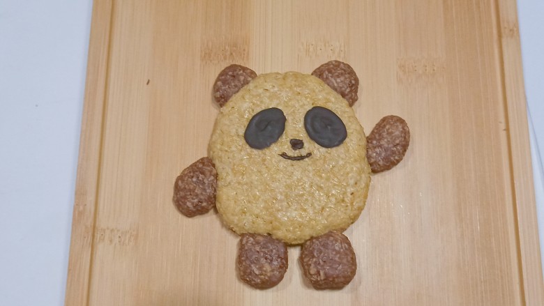 #闹元宵#燕麦冰墩墩饼干,再用巧克力把眼睛的部分粘在饼干相应位置上,顺便画上鼻子和嘴巴