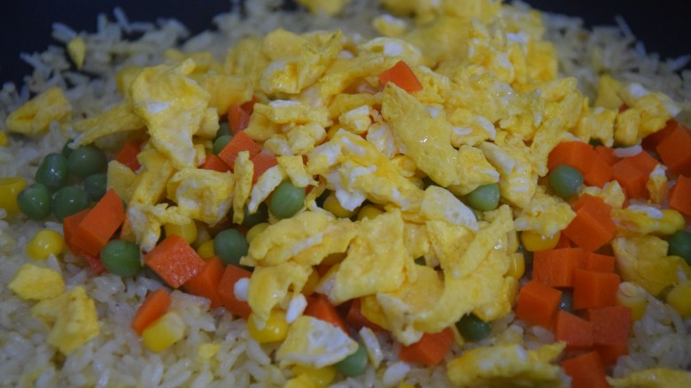 三丁蛋炒饭,倒入蛋块和三色丁,炒至米饭在锅里跳舞