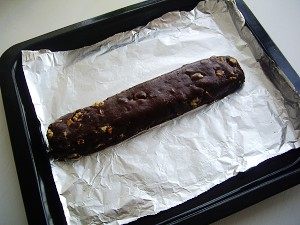 巧克力坚果意式脆饼,用刮刀切拌均匀,将面糊直接放在铺了烤盘纸的烤盘里,用手整形成长条状;